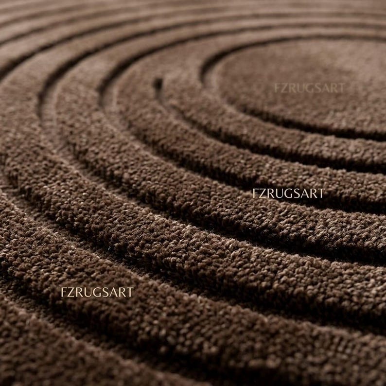 May include: A dark brown rug featuring a textured surface with concentric circular patterns. The text FZRUGSART is visible in multiple locations across the rug, which has a deep pile and a consistent monochromatic brown color throughout the design.
