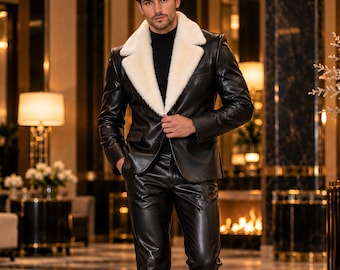 Può includere: Un blazer in pelle nera con un ampio bavero in ecopelliccia bianca, indossato sopra un maglione a collo alto nero e pantaloni in pelle nera abbinati. L'insieme è completato da scarpe eleganti in pelle nera, creando un look monocromatico.