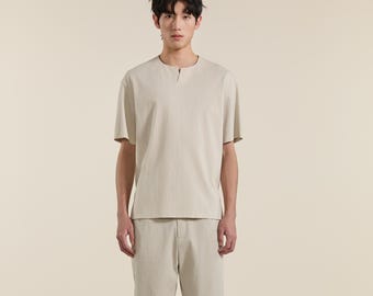 Camiseta de hombre color gris albaricoque, corte relajado, mezcla de algodón, cuello con abertura, top minimalista de verano.