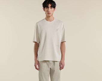 Camiseta de hombre extragrande color gris albaricoque, mezcla de algodón elástico, top de verano con estampado gráfico minimalista.