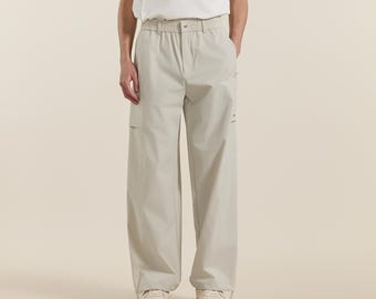 Pantalones cargo minimalistas de pierna ancha y corte holgado para hombre, de nailon color albaricoque claro.