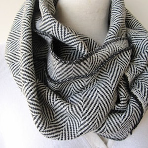 Peut inclure: Une écharpe infinie en chevron noir et blanc. L'écharpe est faite d'un tissu doux et chaud, idéale pour vous tenir au chaud en hiver.