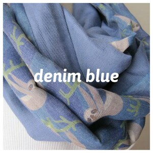 May include: A denim blue infinity scarf with a pattern of sloths hanging from branches. The scarf is soft and comfortable and perfect for keeping warm in the winter.