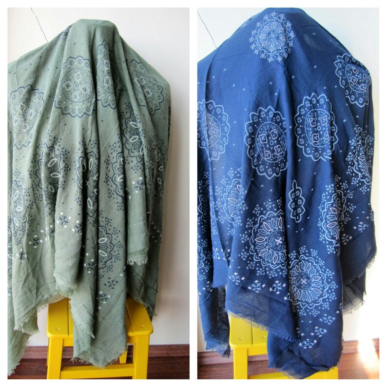 May include: Two fabric squares with a paisley pattern. One square is green with a white paisley pattern and the other is blue with a white paisley pattern.