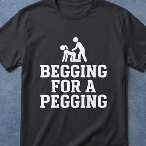 Könnte beinhalten: Schwarzes T-Shirt mit dem weißen Text "BEGGING FOR A PEGGING" und einer Grafik von zwei Strichmännchen. Das Shirt hat auch den Text "100% COTTON BLACK T-SHIRT".