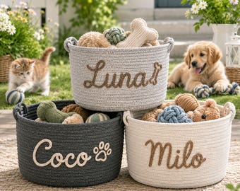 Könnte beinhalten: Drei runde Aufbewahrungskörbe aus geflochtenem Seil in Hellgrau, Dunkelgrau und Cremeweiß. Die Körbe sind mit den gestickten Namen Luna, Coco und Milo in Schreibschrift versehen, ergänzt durch ein Knochen- und ein Pfotenabdruck-Symbol vorne.