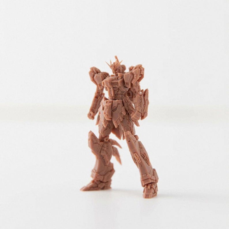 Pode incluir: Um modelo castanho detalhado de um rob&ocirc; com membros articulados e uma intrincada armadura. O rob&ocirc; tem uma estrutura semelhante a uma coroa na cabe&ccedil;a e est&aacute; em p&eacute;. O modelo est&aacute; sobre um fundo branco liso.
