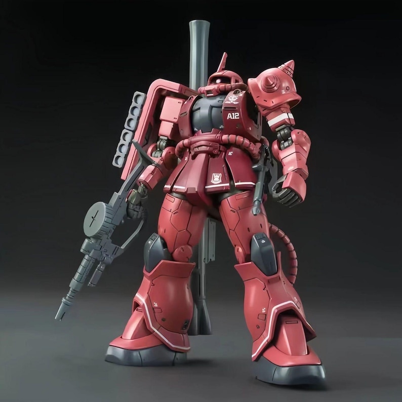 Puede incluir: Un modelo rojo y gris de un robot m&oacute;vil, con un arma grande y otras armas. El robot tiene un dise&ntilde;o detallado con varios paneles, articulaciones y una cabeza distintiva. El modelo est&aacute; sobre una superficie gris.