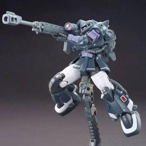 Puede incluir: Un kit de modelo gris oscuro y p&uacute;rpura de un robot de traje m&oacute;vil, posado en una postura de acci&oacute;n din&aacute;mica. El robot sostiene un rifle gris grande con una mira telesc&oacute;pica. El modelo tiene detalles blancos en las piernas y est&aacute; montado en un soporte gris.