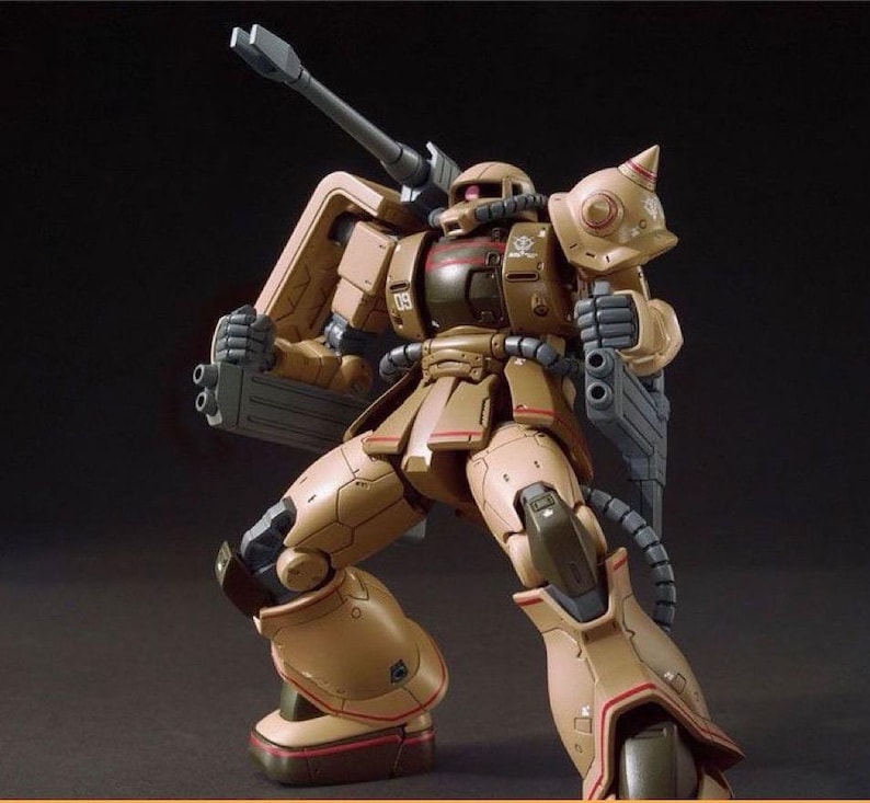 Puede incluir: Modelo de robot m&oacute;vil de color marr&oacute;n y beige, en pose din&aacute;mica. El robot tiene un ca&ntilde;&oacute;n grande y sostiene un arma. Detalles rojos y el n&uacute;mero "09" son visibles. Modelo detallado, ideal para coleccionistas.