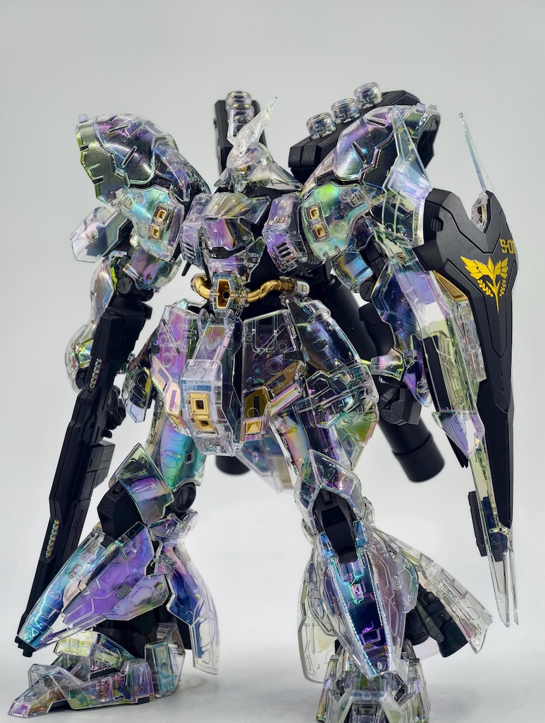 May include: A detailed model of a robot with iridescent, transparent armor. The robot has black and gold accents, including a shield with a gold emblem. The armor reflects a rainbow of colors, including purple, green, and yellow. The model is highly detailed.