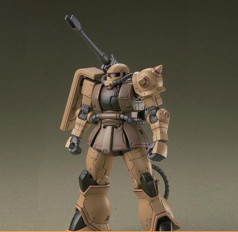 Puede incluir: Modelo de robot militar marr&oacute;n y beige con un gran ca&ntilde;&oacute;n. El robot presenta un dise&ntilde;o detallado con varios componentes mec&aacute;nicos, incluyendo una hombrera con p&uacute;as y una estructura tubular.
