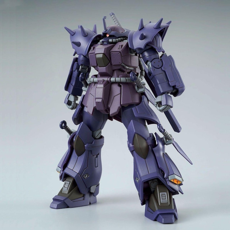 May include: A purple robotic action figure featuring spiked shoulder armor, a mono-eye sensor, and a sword hilt mounted on the hip. The figure has articulated joints, a dark purple chest plate, and grey mechanical details on the legs and feet.