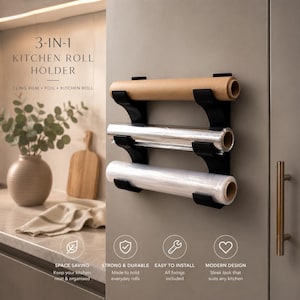 May include: A black 3-in-1 kitchen roll holder mounted on a wall, designed to hold three rolls including cling film, foil, and kitchen roll. The unit features three stacked horizontal brackets that secure the rolls in place for easy access.
