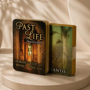 May include: A rectangular metal tin and a deck of oracle cards titled Past Life Oracle Cards by Doreen Virtue and Brian L. Weiss, M.D. The tin features an arched doorway, while the cards show an underwater scene with dolphins and the word Atlantis.