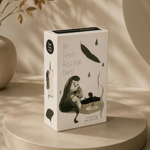 Puede incluir: Una caja rectangular blanca para cartas de tarot titulada The Future Ancestor Tarot con ilustraciones en tinta negra de una figura, hojas y gotas. La caja presenta el texto art & words by lexa luna studio y un logotipo circular.