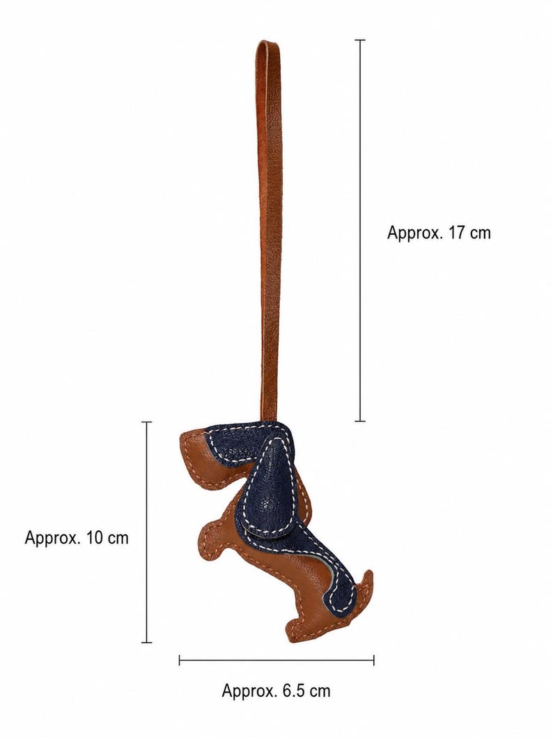 May include: A brown and navy blue leather dog-shaped keyring with white stitching. The keyring is approximately 10 cm tall and 6.5 cm wide, with a brown leather loop. The total length, including the loop, is about 17 cm.