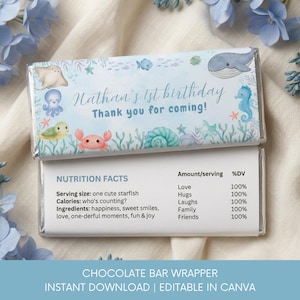 May include: A rectangular chocolate bar wrapper featuring a light blue watercolor ocean theme with illustrations of a whale, crab, octopus, and sea life. The text reads Nathan's 1st birthday Thank you for coming and includes a nutrition facts label.