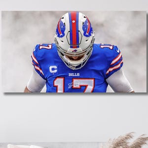 Pode incluir: Uma impressão de arte de parede retangular apresentando um jogador de futebol americano em uma camisa azul com o número 17 e a palavra BILLS no peito. O jogador usa um capacete branco com listras vermelhas e azuis e um emblema de capitão.