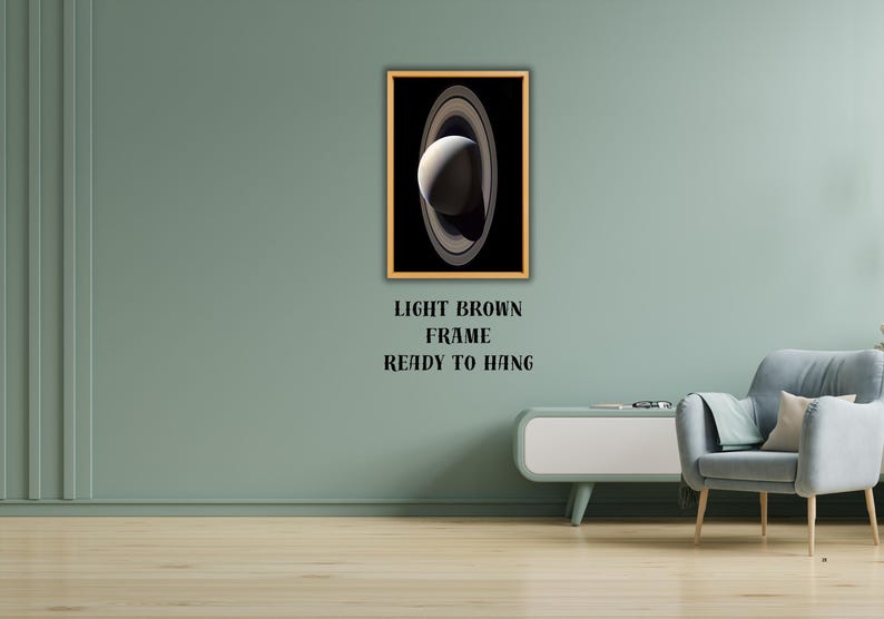 May include: A rectangular wall art print featuring a high-contrast image of the planet Saturn with its prominent rings against a deep black background, encased in a light brown frame with the text LIGHT BROWN FRAME READY TO HANG below it.