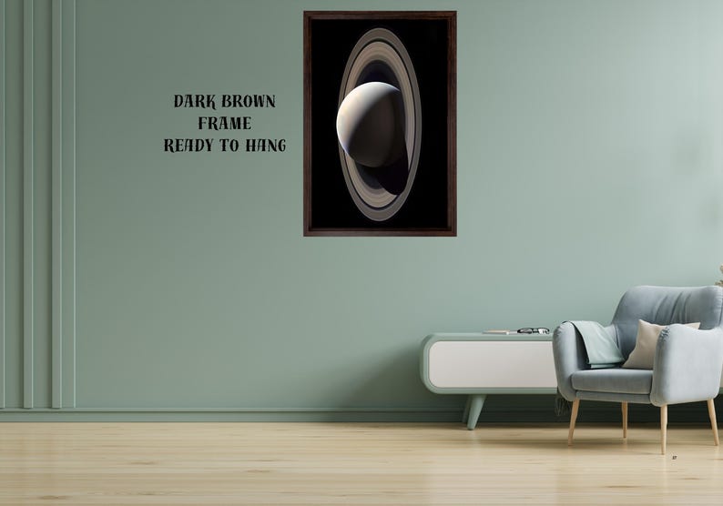 May include: A framed wall art print featuring a detailed image of the planet Saturn with its prominent rings against a black background. The artwork is enclosed in a dark brown frame. The text "DARK BROWN FRAME READY TO HANG" is visible.