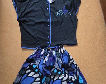 Conjunto vintage dos anos 70 da New Jean Girard Paris France, composto por saia e blusa, estampa de borboletas e bordados azuis.