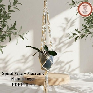 Könnte beinhalten: Ein cremefarbener Makramee-Pflanzenhänger mit Spiral-Knotenmuster, der einen dunkelgrauen Topf mit einer grünen Pflanze hält. Der Text Spiral Vine – Macramé Plant Hanger PDF Pattern ist unten links im Bild zu sehen.