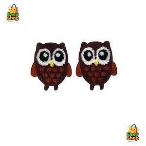 May include: Two embroidered owl patches. Each owl has a dark brown body, light brown wings, and large white eyes with black pupils. The owl's chest is a lighter brown with a diamond pattern, and a yellow beak.