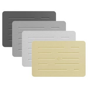 May include: Four rectangular, textured mats in shades of gray, silver, white, and tan. Each mat has a series of horizontal grooves and a rounded corner design. The tan mat features a small logo.