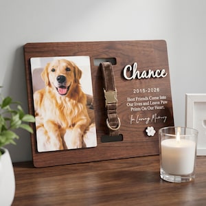 Puede incluir: Marco conmemorativo de madera para mascotas con una foto de un golden retriever, un collar marrón y el nombre "Chance". El texto dice: "Best Friends Come Into Our lives and Leave Paw Prints On Our Heart." Hay una vela encendida al lado.