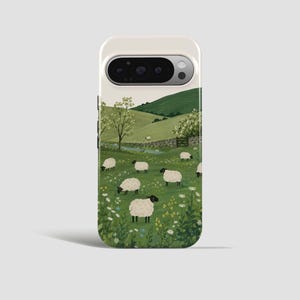 以下が含まれることがあります： 牧歌的な風景が描かれた携帯電話ケース。緑の牧草地で草を食む羊、丘、石垣、小川が描かれています。空は明るく、のどかな雰囲気を作り出しています。