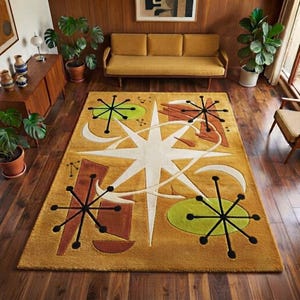 Può includere: Un tappeto rettangolare con sfondo giallo senape e un grande disegno a stella bianca al centro. Il tappeto presenta motivi neri a forma di stella in stile atomico, forme ovali verde chiaro e figure geometriche marroni sulla superficie.
