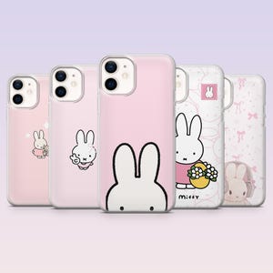 Op de afbeelding: Vijf telefoonhoesjes met Miffy-ontwerpen. De hoesjes zijn voornamelijk roze en wit, met illustraties van het stripfiguur. Eén hoesje heeft het woord 'Miffy' erop gedrukt, en een ander een konijn met een bloemenmand.