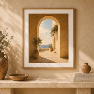 Peut inclure: Une impression d'art encadrée représentant une arche en pierre donnant sur la mer, posée sur une console en pierre avec un grand vase en terre cuite, un bol en bois peu profond et trois livres intitulés Live Beautiful, This Is Home et The Kinfolk.