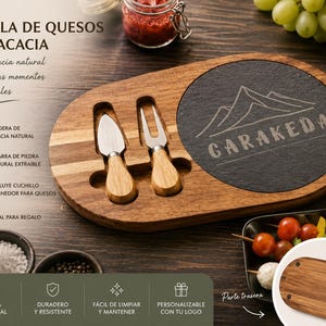 Puede incluir: Tabla de quesos de madera de acacia con una inserción de pizarra extraíble. Incluye un cuchillo y un tenedor para queso. La tabla presenta el texto "GARAKEDA" y un diseño de montaña. 100% natural.