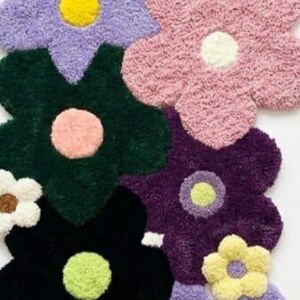 May include: A tufted rug featuring a cluster of overlapping flower shapes in various colors including lavender, pink, dark green, deep purple, black, white, and yellow. Each flower has a contrasting circular center in a different color.