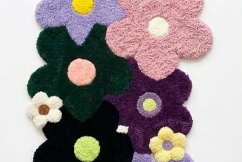May include: A tufted rug featuring a cluster of overlapping flower shapes in various colors including lavender, pink, dark green, deep purple, black, white, and yellow. Each flower has a contrasting circular center in a different color.