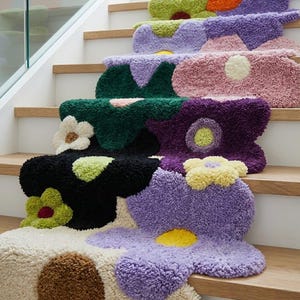May include: A set of tufted stair treads featuring a multi-colored floral pattern. Each tread displays large, abstract flower shapes in shades of orange, lime green, purple, pink, dark green, black, yellow, cream, and brown with a textured pile.