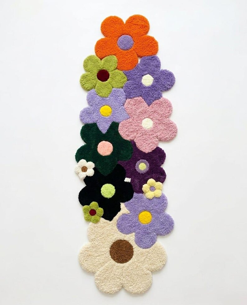 May include: A tufted rug shaped like a vertical cluster of overlapping flowers in various colors including orange, lime green, lavender, pink, dark green, black, cream, and purple, each featuring a contrasting circular center in a different hue.