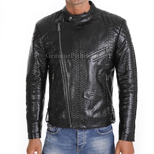 May include: Black leather jacket with a snakeskin texture, featuring a diagonal zip, multiple pockets, and the text "Genuine Python". The jacket has a stand-up collar and is worn with blue jeans.