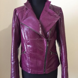 May include: A striking purple leather jacket with a snakeskin pattern. The jacket has a diagonal zip, a notched collar, and two zipped pockets. The text "genuinePythonjacket" is visible on the jacket.