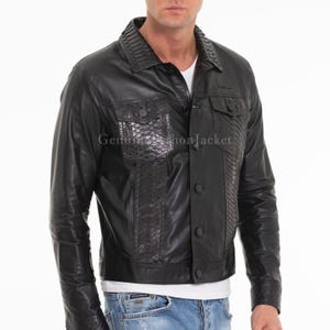 Könnte beinhalten: Eine schwarze Jacke mit einem glatten Lederkörper und strukturierten Einsätzen mit Schlangenledermuster am Kragen, an den Brusttaschen und an den vertikalen Vorderteilen. Das Kleidungsstück verfügt über eine Knopfleiste vorne und lange Ärmel.
