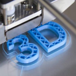 May include: A 3D printer nozzle extrudes blue plastic filament to form the letters 3D on a flat metal build plate. The letters feature a visible internal lattice structure, and the printer head is positioned directly above the blue plastic object.