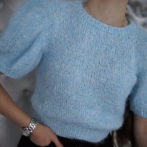 Suéter corto de mohair azul claro y suave con pequeñas lentejuelas azules, top de punto ligero y esponjoso.
