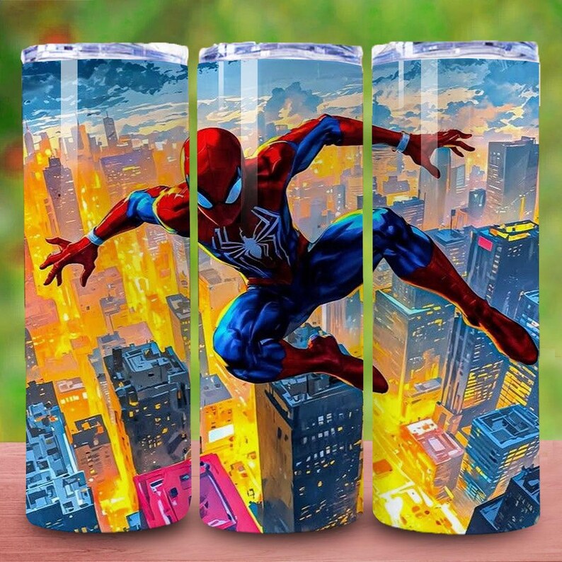 May include: Three stainless steel tumblers with a vibrant illustration of Spider-Man soaring over a cityscape. The superhero is depicted in his classic red and blue suit, set against a backdrop of tall buildings and a colorful sky.
