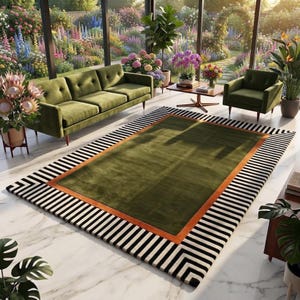 May include: A rectangular area rug featuring a solid olive green center, a burnt orange border, and a wide outer frame with black and white diagonal stripes. The rug is positioned on a white marble floor in a room with green furniture.