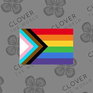 May include: A rectangular flag featuring the Progress Pride flag design. The flag includes the traditional rainbow colors, along with a chevron of pink, light blue, brown, black, and white. The background is gray with a repeating clover pattern and the text "CLOVER THE WORLD".
