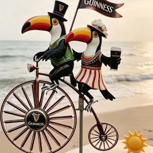 May include: A decorative metal sculpture featuring two toucans riding a penny-farthing bicycle. One toucan wears a top hat and the other holds a Guinness pint. The bicycle has a Guinness logo on the wheel and a banner that says "Guinness".