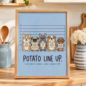 Könnte beinhalten: Ein gerahmter Druck auf hellblauem Hintergrund mit einer polizeilichen Gegenüberstellung von fünf Hunden, die Schilder mit der Aufschrift Floof Potato, Couch Potato, Tater Tot, Chunky Potato und Sausage Potato halten. Text: POTATO LINE UP. DIFFERENT SHAPES. SAME ENERGY.