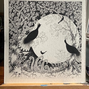 May include: Black and white ink drawing of a moon with birds and plants. The moon is surrounded by a circle of trees and branches. The birds are perched on the branches and the plants are growing at the bottom of the image.